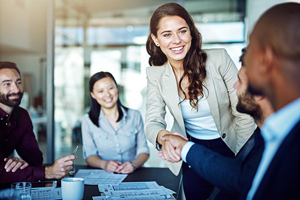 AHA Mission Statement. A staff member shaking hands with a businessman in a conference room.